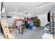 Spacious garage, featuring a ceiling fan, storage boxes, a television and workspace at 379 Peppertree Rd, Venice, FL 34293