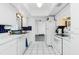 Efficient kitchen featuring white cabinetry, white appliances, and contrasting dark tile backsplash at 379 Peppertree Rd, Venice, FL 34293