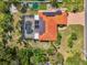 Aerial shot showing a house with a red tile roof, a screened pool, solar panels, a putting green and landscaping at 403 Picasso Dr, Nokomis, FL 34275