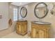Elegant bathroom features dual vanities with decorative mirrors, tiled walls, and ample storage space at 403 Picasso Dr, Nokomis, FL 34275
