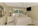 Bright bedroom features a comfortable bed, two nightstands with lamps, and a TV mounted on the wall at 403 Picasso Dr, Nokomis, FL 34275