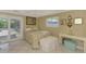 Comfortable bedroom with floral bedding, white tile floor, and sliding glass doors at 403 Picasso Dr, Nokomis, FL 34275