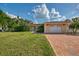 Charming home with attached two-car garage, brick driveway, and a neatly kept lawn at 403 Picasso Dr, Nokomis, FL 34275