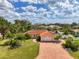 Stunning single-story home boasts a red tile roof, brick driveway, and lush landscaping at 403 Picasso Dr, Nokomis, FL 34275