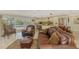Spacious living room featuring tile floors, leather furniture, and a view of the outdoor area through sliding glass doors at 403 Picasso Dr, Nokomis, FL 34275