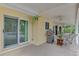 Covered patio with outdoor grill, fan, and comfortable seating area at 403 Picasso Dr, Nokomis, FL 34275