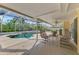 Screened-in pool area with a refreshing pool, comfortable seating and tropical landscaping at 403 Picasso Dr, Nokomis, FL 34275