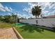 Backyard putting green bordered by brick and tropical landscaping at 403 Picasso Dr, Nokomis, FL 34275