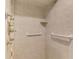 Close-up of a tiled shower with grab bars, a built-in shelf, and a multi-head shower system at 403 Picasso Dr, Nokomis, FL 34275