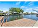 Waterfront backyard showcasing a wooden dock, providing access to the canal and boating opportunities at 4255 13Th Ne Ln, St Petersburg, FL 33703