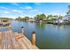 Backyard canal view features a wooden dock and waterway with several boats docked nearby at 4255 13Th Ne Ln, St Petersburg, FL 33703