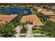 Beautiful aerial view of home with a manicured lawn, landscaping, and a tranquil lake backdrop at 4321 Via Del Santi Dr, Venice, FL 34293