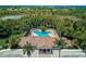 Aerial view of community pool with uniquely shaped design surrounded by lush green landscape at 4321 Via Del Santi Dr, Venice, FL 34293