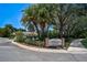 A community entrance with mature trees, lush landscaping and decorative signage at 4321 Via Del Santi Dr, Venice, FL 34293