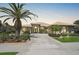 Beautiful home boasting a tile roof, arched windows, and a well-manicured lawn with palm trees at 4321 Via Del Santi Dr, Venice, FL 34293