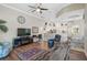 Comfortable living room featuring wood floors, a ceiling fan, and large windows for natural light and an open floor plan at 4321 Via Del Santi Dr, Venice, FL 34293