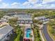 Aerial view featuring a pool, lake, and condos, showcasing a residential community with ample recreational opportunities at 442 Sunset Lake Blvd # 104, Venice, FL 34292