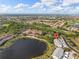 Aerial view of the condominium complex near a peaceful lake and a manicured golf course on a clear day at 442 Sunset Lake Blvd # 104, Venice, FL 34292