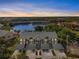 Aerial view of community buildings surrounding a central pond, all with covered parking at 442 Sunset Lake Blvd # 104, Venice, FL 34292
