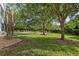 Well-manicured backyard featuring mature trees and lush green grass at 442 Sunset Lake Blvd # 104, Venice, FL 34292