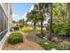 A beautifully landscaped backyard with a stone pathway and lakeside view with palm trees creating a serene outdoor space at 442 Sunset Lake Blvd # 104, Venice, FL 34292