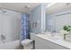 Bathroom with a shower-tub combo, blue and white floral shower curtain, and white vanity at 442 Sunset Lake Blvd # 104, Venice, FL 34292