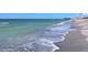 Waves gently lapping on the sandy shore at 442 Sunset Lake Blvd # 104, Venice, FL 34292