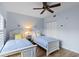 Bright bedroom showcasing twin beds, coastal decor, light blue walls, and a ceiling fan at 442 Sunset Lake Blvd # 104, Venice, FL 34292