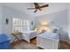 Light and airy bedroom featuring two beds, wood floors, and a coastal-inspired design at 442 Sunset Lake Blvd # 104, Venice, FL 34292