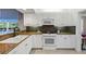 Well-equipped kitchen with white cabinetry, granite counters, and a view of the living area at 442 Sunset Lake Blvd # 104, Venice, FL 34292