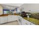 Modern kitchen boasts granite countertops, white cabinets, and open layout with living area access at 442 Sunset Lake Blvd # 104, Venice, FL 34292