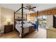 Spacious main bedroom with four poster bed, ceiling fan, and private lanai access at 442 Sunset Lake Blvd # 104, Venice, FL 34292