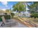 Back patio space with chairs and a lake view, surrounded by lush landscaping, offering a peaceful outdoor living experience at 442 Sunset Lake Blvd # 104, Venice, FL 34292