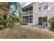 A relaxing patio area with lounge chairs and a screened-in lanai, perfect for enjoying the landscaped backyard and lakeside scenery at 442 Sunset Lake Blvd # 104, Venice, FL 34292