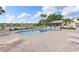 Community pool with a large patio area, surrounded by lounge chairs, and views of the lake at 442 Sunset Lake Blvd # 104, Venice, FL 34292