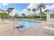 Community pool surrounded by lounge chairs, lush greenery, and palm trees for a relaxing outdoor experience at 442 Sunset Lake Blvd # 104, Venice, FL 34292