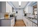 Well-lit kitchen with white cabinets, granite countertops, stainless steel appliances and hardwood floors at 4531 Crystal Rd, Venice, FL 34293