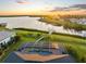 Beautiful aerial view showcasing a screened pool, lush lawn, and waterfront access at sunset at 5035 Collingswood Blvd, Port Charlotte, FL 33948