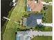 An aerial view shows the home with a private dock and screened-in pool along a canal leading to the Gulf at 5035 Collingswood Blvd, Port Charlotte, FL 33948
