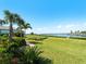 Expansive backyard featuring lush green grass extending to the water with a dock at 5035 Collingswood Blvd, Port Charlotte, FL 33948