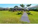 Well-manicured lawn with landscaping and a boardwalk leading to the waterfront, a beautiful backyard at 5035 Collingswood Blvd, Port Charlotte, FL 33948