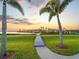 Waterfront backyard with tropical palm trees, a pathway to the dock, and scenic views at 5035 Collingswood Blvd, Port Charlotte, FL 33948