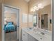 Bathroom with double sinks, vanity, and a clear view to the adjoining bedroom and shower at 5035 Collingswood Blvd, Port Charlotte, FL 33948