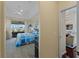 View of the main bedroom from the hall, featuring coastal decor and sliding glass doors to the lanai at 5035 Collingswood Blvd, Port Charlotte, FL 33948