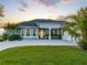 A picturesque home featuring a large driveway, beautiful lawn, and tropical palm trees at 5035 Collingswood Blvd, Port Charlotte, FL 33948