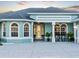 Close up of arched windows and decorative front door with seating area at 5035 Collingswood Blvd, Port Charlotte, FL 33948