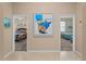 Hallway featuring views into two bedrooms, with coastal-inspired decor and ample natural light at 5035 Collingswood Blvd, Port Charlotte, FL 33948
