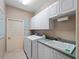 Well-lit laundry room with modern washer and dryer, built-in cabinets, and a utility sink at 5035 Collingswood Blvd, Port Charlotte, FL 33948