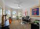 Bright home office with three large arched windows, neutral walls, ceiling fan, and comfortable seating area at 5035 Collingswood Blvd, Port Charlotte, FL 33948