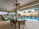 Relaxing screened-in patio with a dining table and view of the pool and the beautiful sunset at 5035 Collingswood Blvd, Port Charlotte, FL 33948